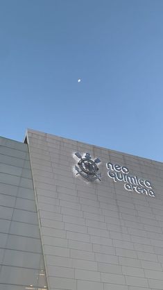 the top of a building with a clock on it's side and an airplane flying overhead