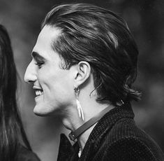 black and white photograph of two women smiling at each other with one woman's face to the side