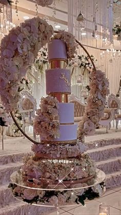 a three tiered wedding cake with flowers on the top and bottom is surrounded by candles