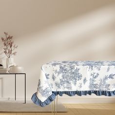 a table with a blue and white cloth on it in front of a vase filled with flowers