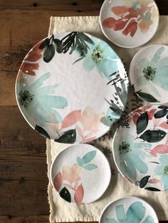 four plates with flowers painted on them