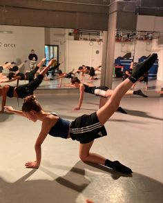 a group of people in a gym doing exercises on their hands and legs with one leg up