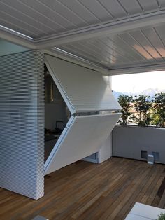 an open window on the side of a building with wood flooring and white siding