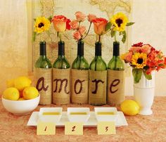 several bottles with flowers and lemons in them sitting on a table next to a map