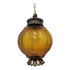 a yellow glass hanging light fixture with an intricate design on the front and back side