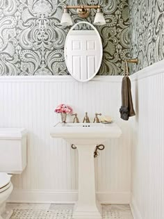 a white sink sitting under a mirror in a bathroom next to a wall mounted faucet