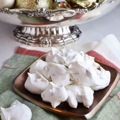 a plate full of marshmallows on a table with christmas decorations in the background