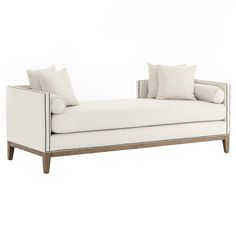 a white chaise lounge with pillows on it