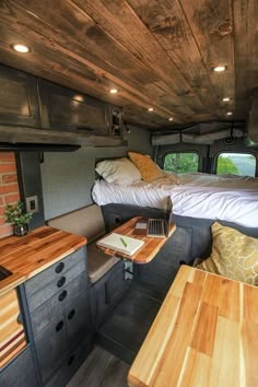 the inside of a camper with two beds and desks in it's center