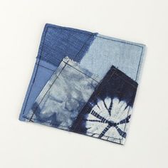 three pieces of blue and white fabric on top of each other, one with a tie dye design