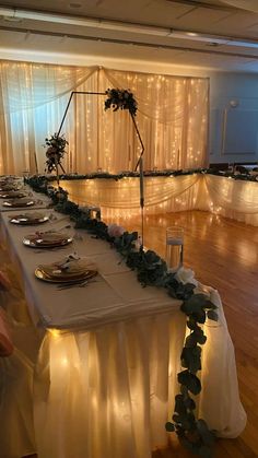 a long table is set up with plates and silverware for an elegant wedding reception