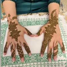 two hands with henna designs on them