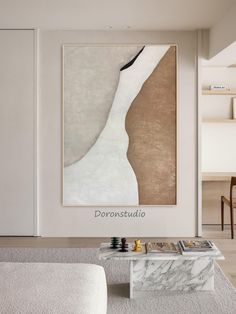 an abstract painting hangs on the wall above a marble coffee table