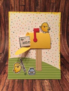 a close up of a mailbox on a wooden surface with polka dotty paper