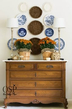 a dresser with plates and flowers on it