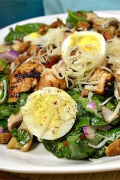 a white plate topped with salad and an egg