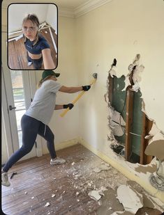 a woman holding a paint roller in front of a wall that has been torn down