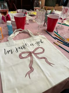 a white bag sitting on top of a table covered in wine glasses and other items