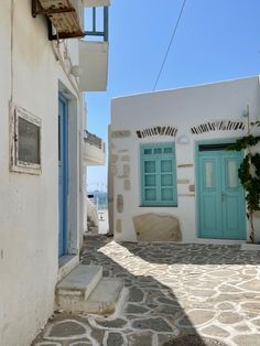 an alley way with blue doors and stone steps