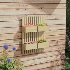 a wooden wall mounted planter filled with flowers