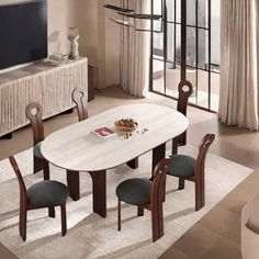 a dining room table with four chairs and a television in the backround area