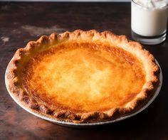 a pie sitting on top of a table next to a glass of milk