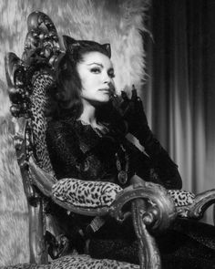 a black and white photo of a woman sitting in a chair with leopard print on it