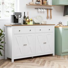 a kitchen with green cupboards and white walls, wooden flooring and open shelves