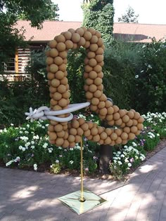 a sign made out of balls and rope in the shape of a number five on a sidewalk