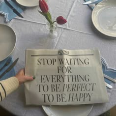 a person is holding up a newspaper that reads stop waiting for everything to be perfect to be happy