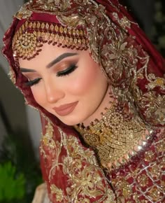 a woman wearing a red and gold bridal veil