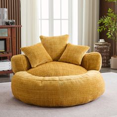 a living room with a large round chair in the middle and pillows on it's back