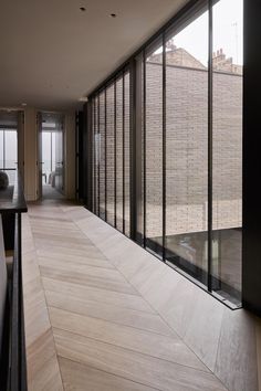 an empty room with wooden floors and large windows on the side of the wall that overlooks a cityscape