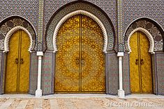 the entrance to an ornate building with gold and blue tiles on it's walls