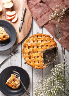 an apple pie is shown on two black plates with one slice missing from the pie