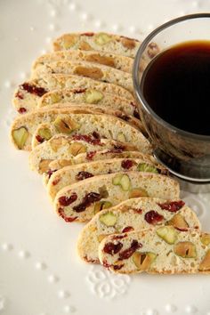 a white plate topped with crackers next to a cup of black liquid on top of it