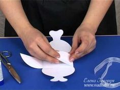 a person cutting out paper with scissors on a table