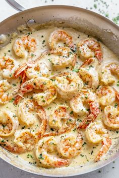 a skillet filled with shrimp and grits on top of a white countertop