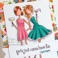 two women in dresses holding wine glasses and one has a card saying girls just wanna have fun