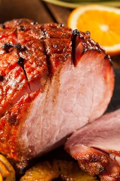 sliced ham sitting on top of a cutting board next to an orange slice