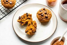 three chocolate chip muffins on a plate next to a cup of coffee