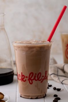 a drink with a straw in it sitting on a table next to cookies and coffee beans