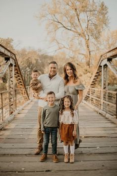 a family standing on a bridge in the fall