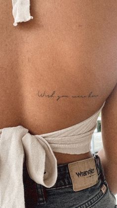 the back of a woman's stomach with writing on her left shoulder and right arm