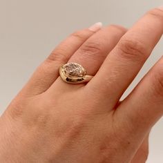 a woman's hand with a ring on it and a diamond in the middle