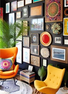 a living room filled with lots of framed pictures on the wall and an orange chair