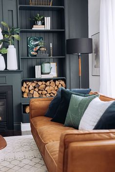 a living room filled with furniture and a fire place in front of a bookshelf