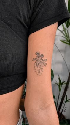 a woman's arm with a tattoo on it and a flower in the heart