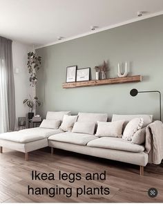 a living room with a large white couch and wooden shelves on the wall, along with text overlay that reads ikea legs and hanging plants