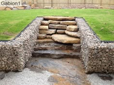 a stone bench made out of rocks in the grass